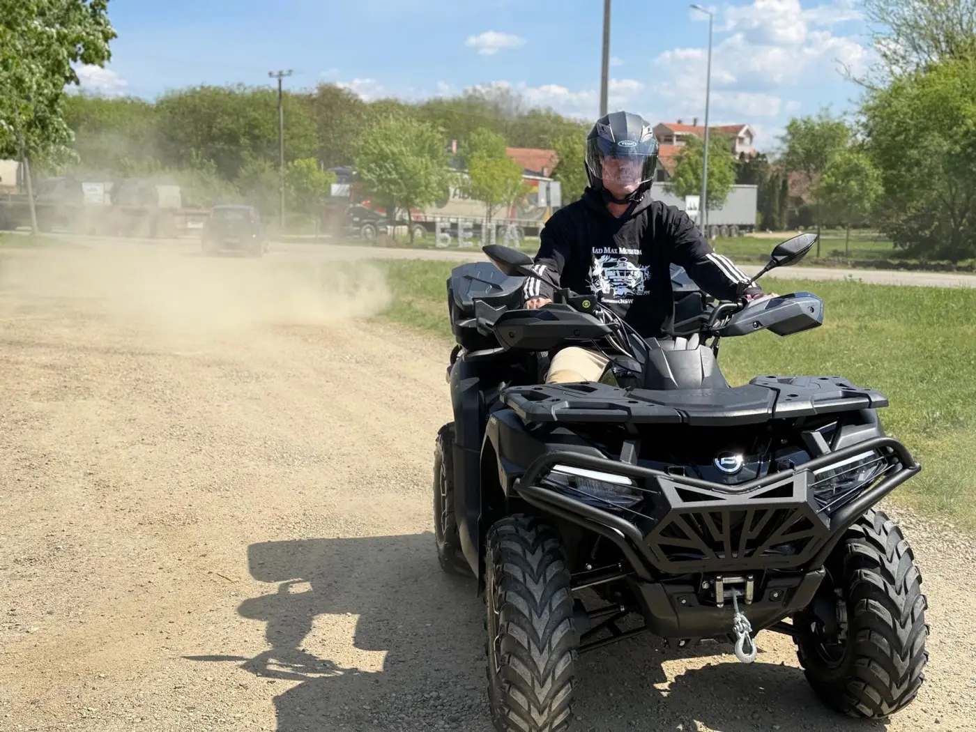 A rider in a Mad Max hoodie powering a quad bike through the dust near Bela Crkva
